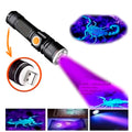 Lanterna LED UV compacta com corpo em alumínio preto, botão lateral e recarga USB. Emite luz ultravioleta ideal para detectar escorpiões, cédulas falsas e outras aplicações ocultas.
