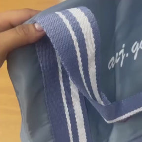 Bolsa de viagem compacta e leve, ideal como mala de mão. Com alças duplas, tiracolo ajustável, bolso lateral e design moderno. Unissex e enviada em cores variadas.